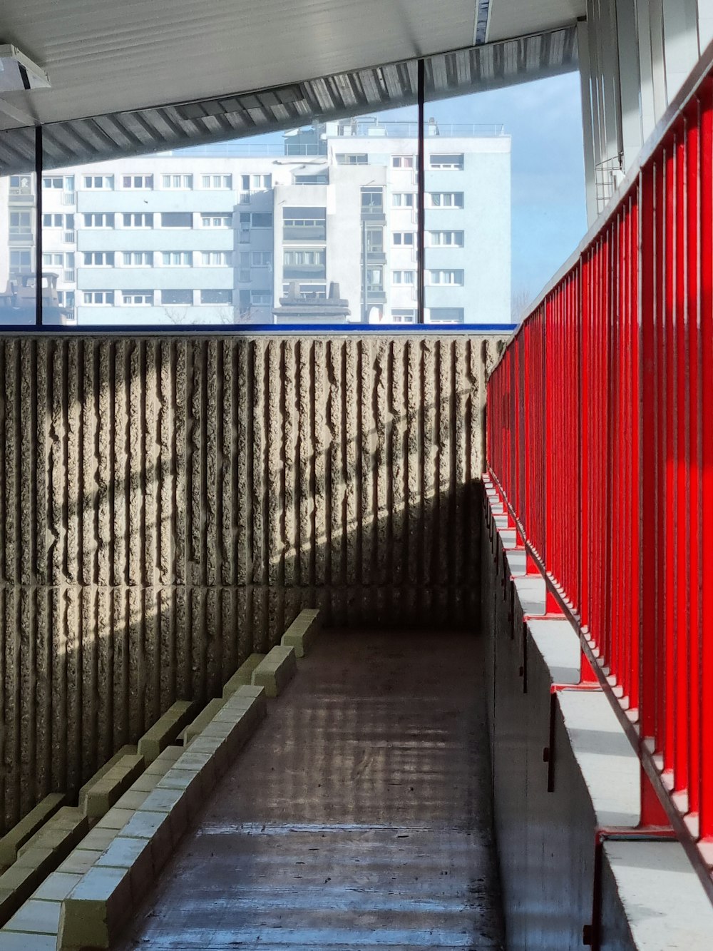 a red and white walkway next to a tall building