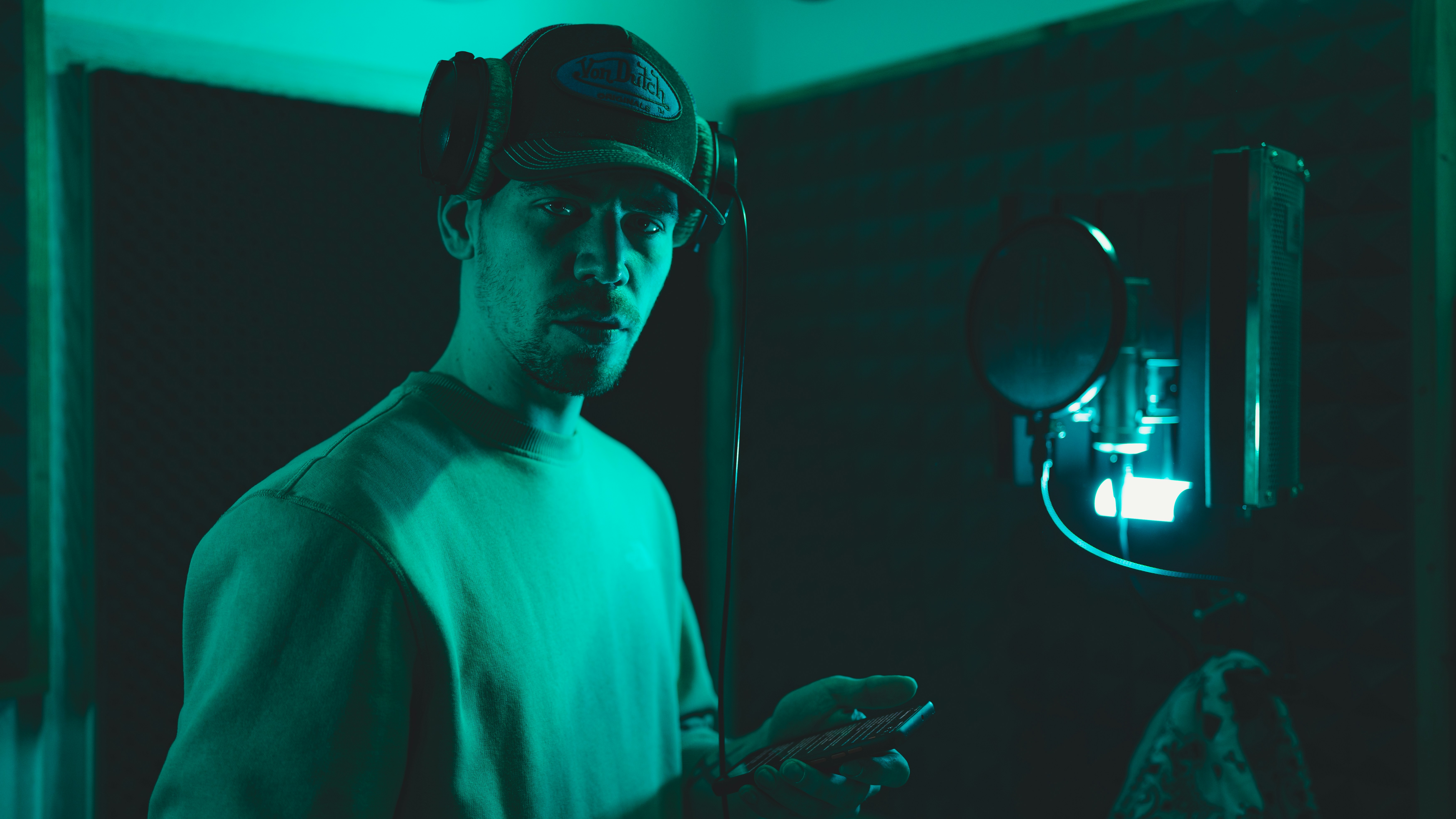 Un hombre con una gorra de béisbol mirando su teléfono celular