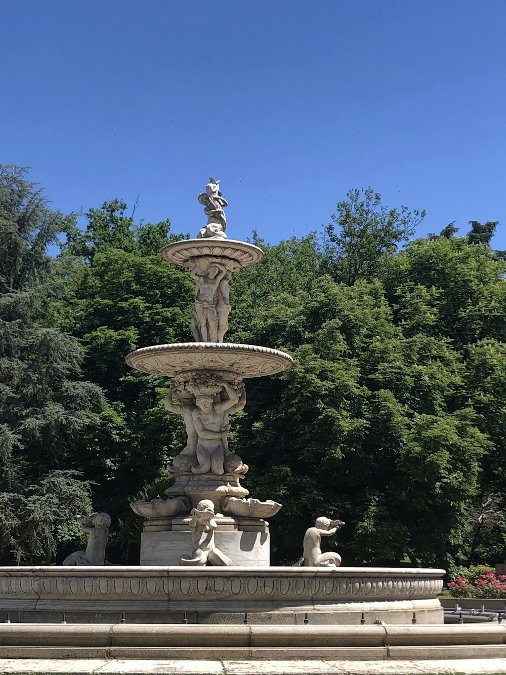 a fountain in a park with a statue on top of it