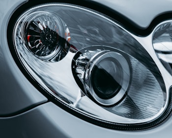Close-up of a car headlight being polished with high-tech equipment.