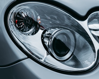 A close-up of a car’s headlight and grille, showcasing intricate design details.