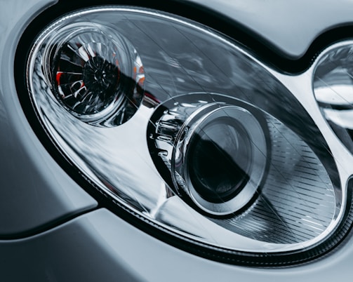 A close-up of a car’s headlight and grille, showcasing intricate design details.