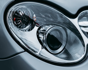 Close-up of a car headlight being repaired with precision tools.