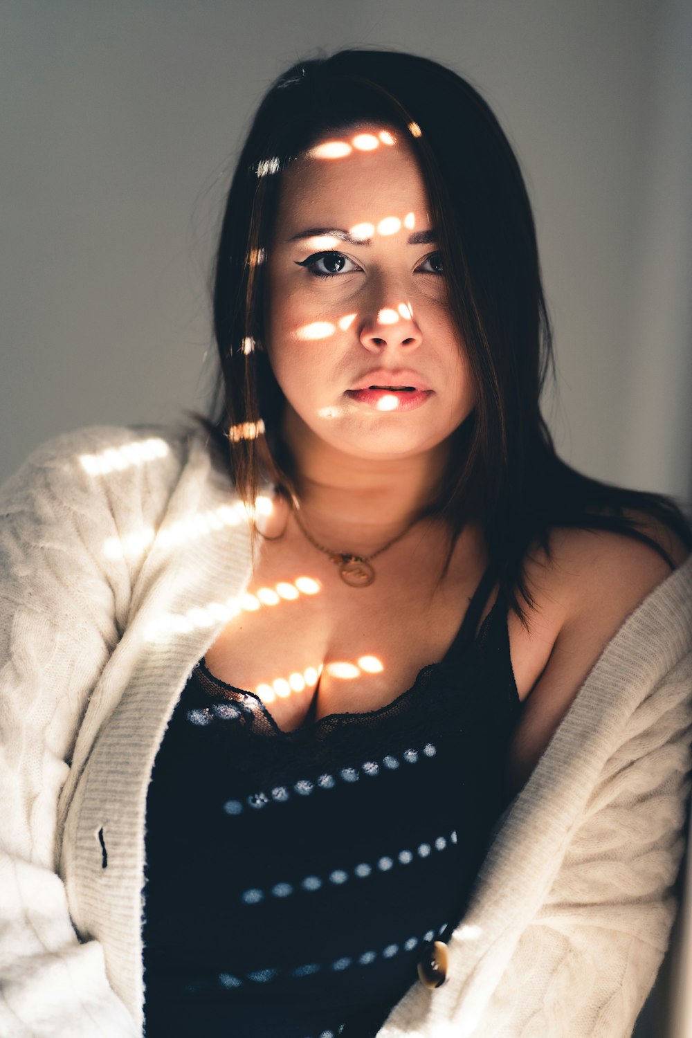 a woman in a black top and a white jacket