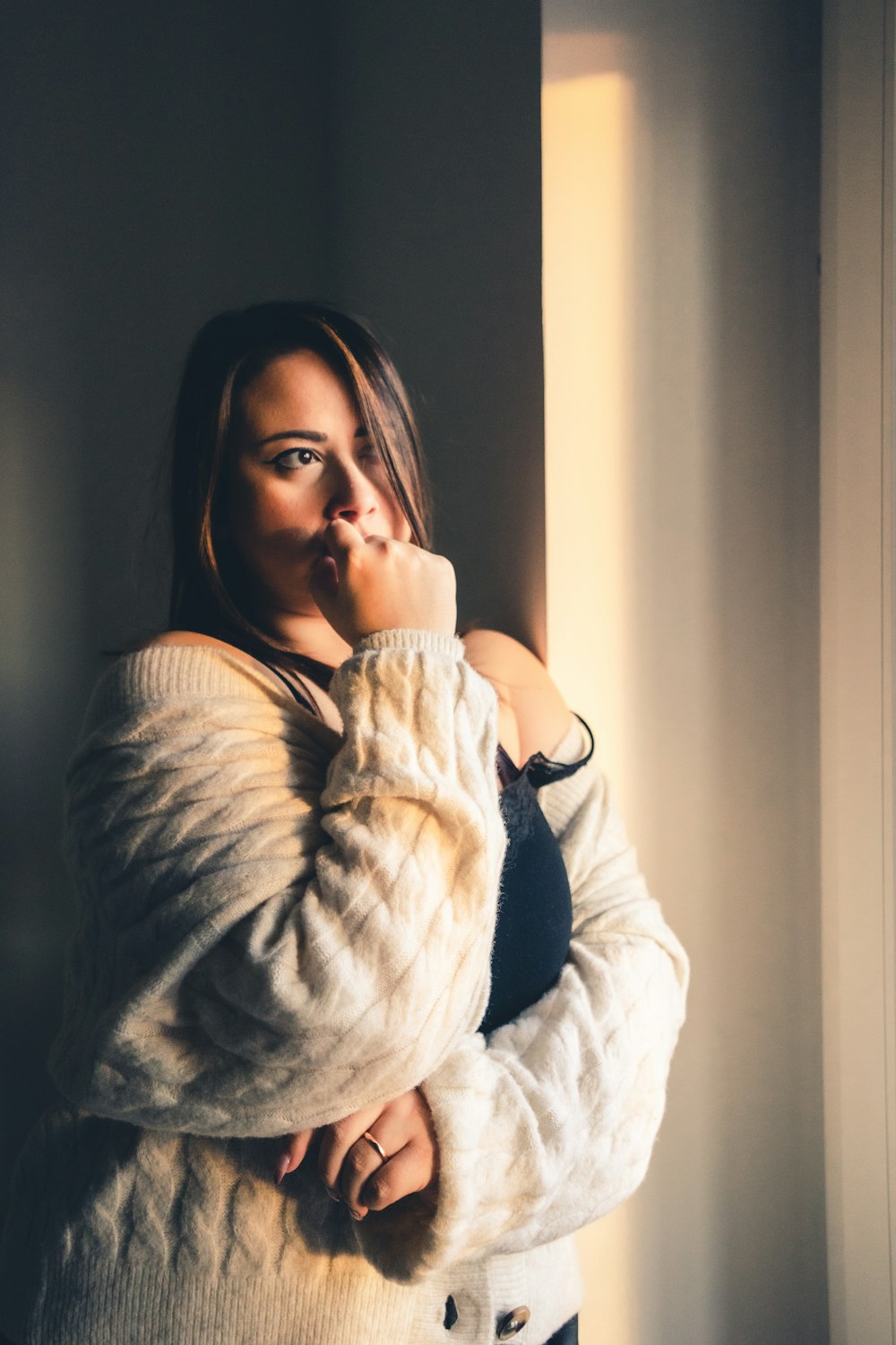 a woman standing in a room with her hand on her face