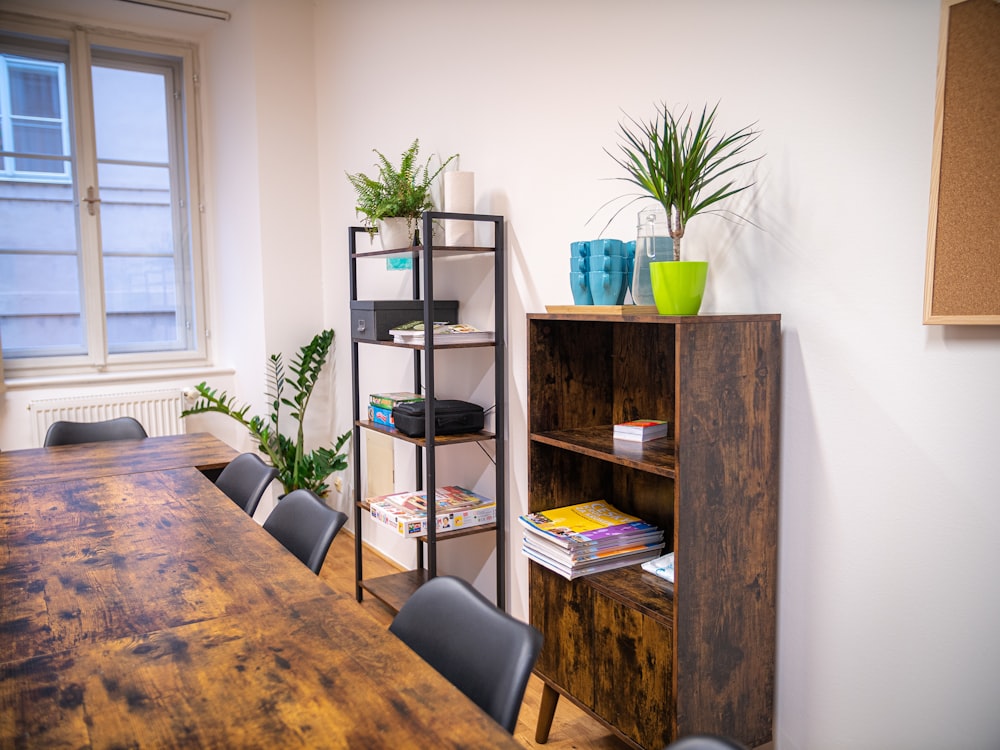 a wooden table with chairs and a book shelf