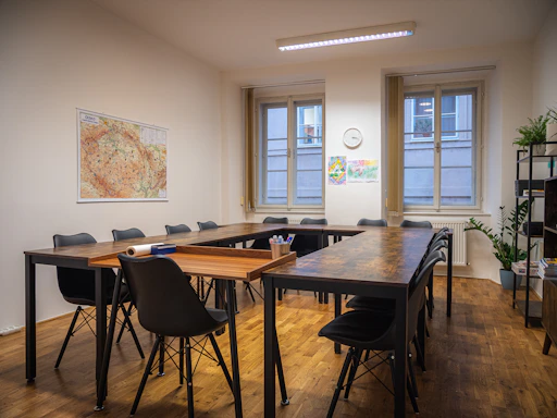 A cozy meeting room with a round table and comfortable chairs bathed in natural light.