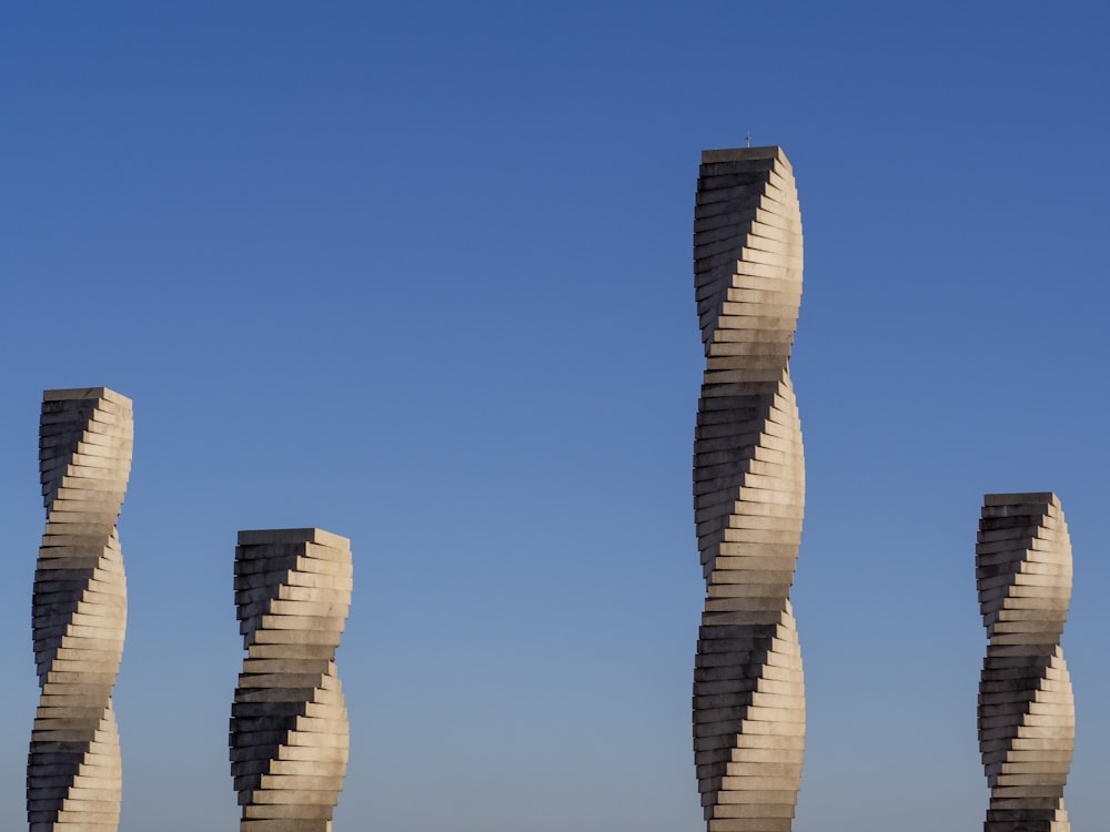 Un grupo de esculturas altas sentadas una al lado de la otra