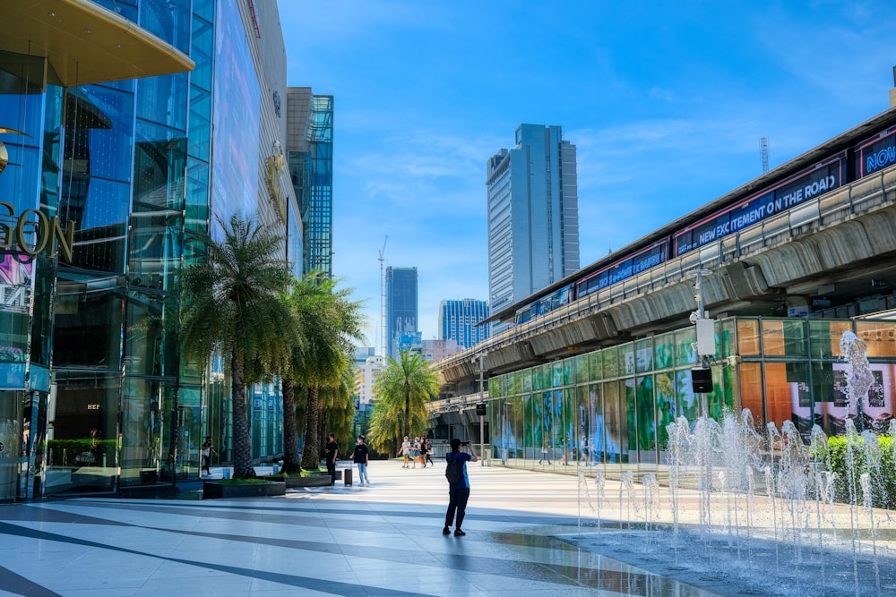 a man walking down a street next to tall buildings