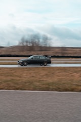 Action shot of a virtual car speeding through a sharp corner on a dark track.