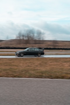 Action shot of a virtual car speeding through a sharp corner on a dark track.