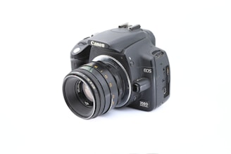 A sleek modern DSLR camera with lens attached, displayed against a clean white background.