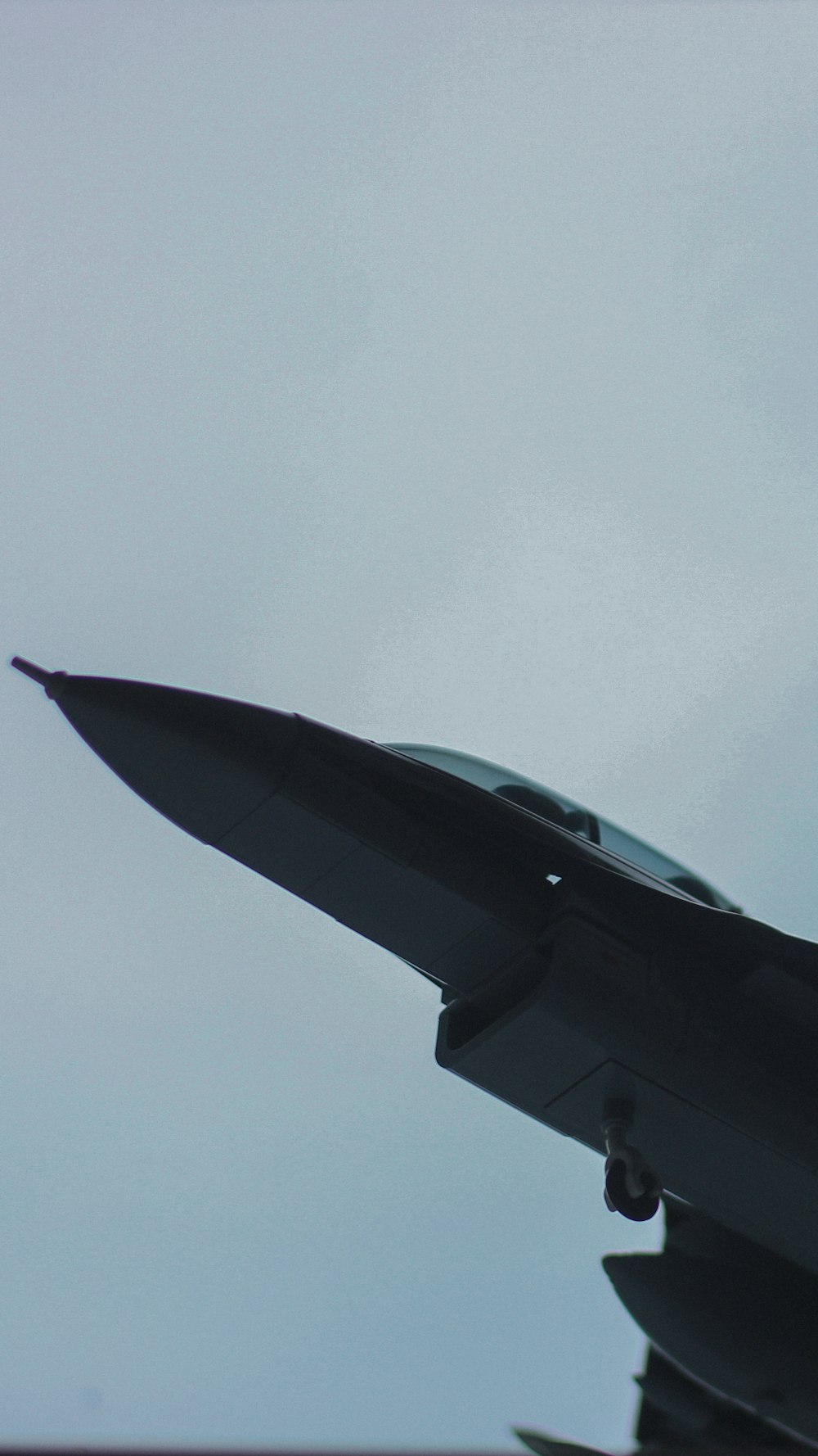 a fighter jet flying through a cloudy sky