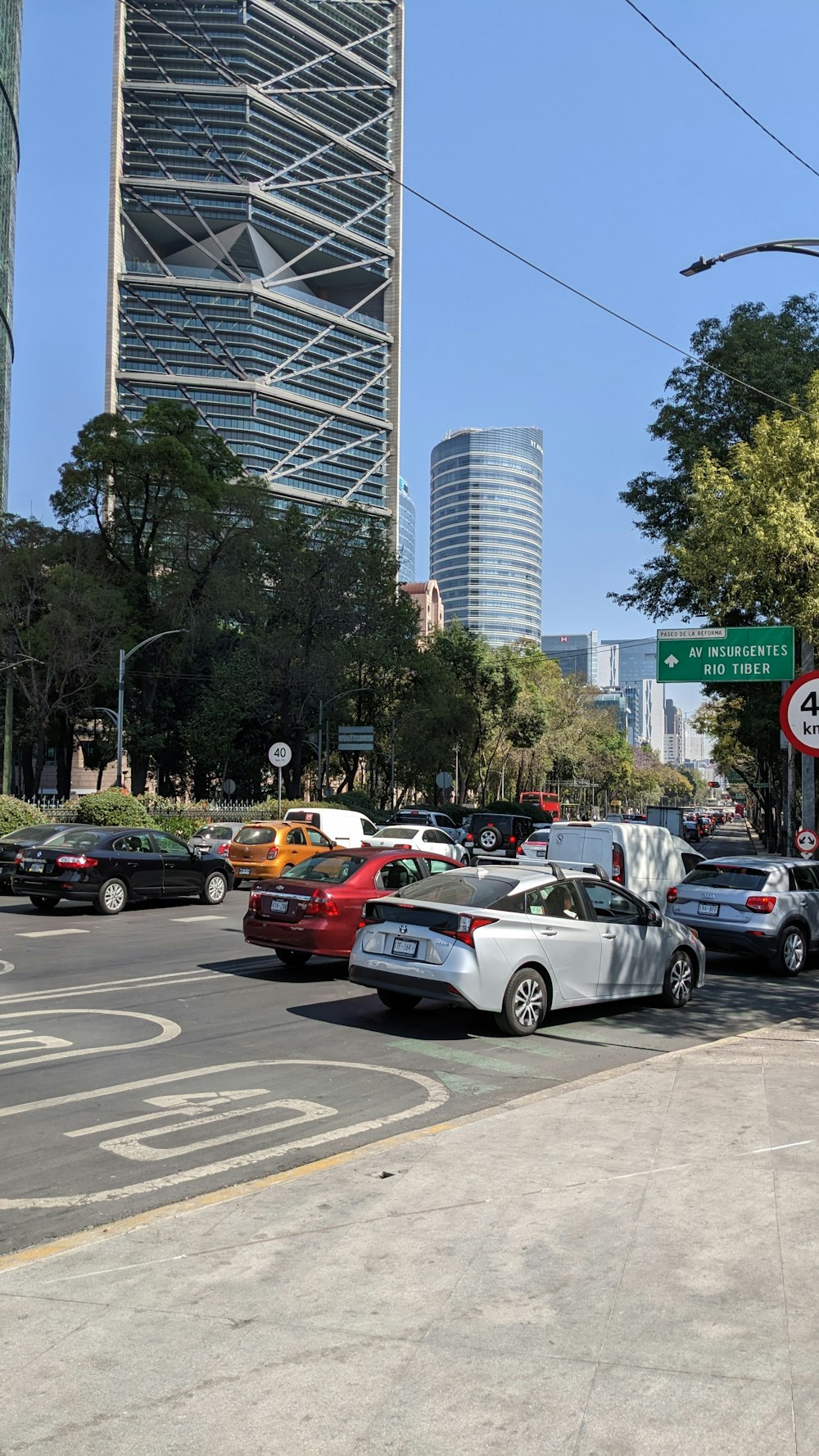 a city street filled with lots of traffic next to tall buildings