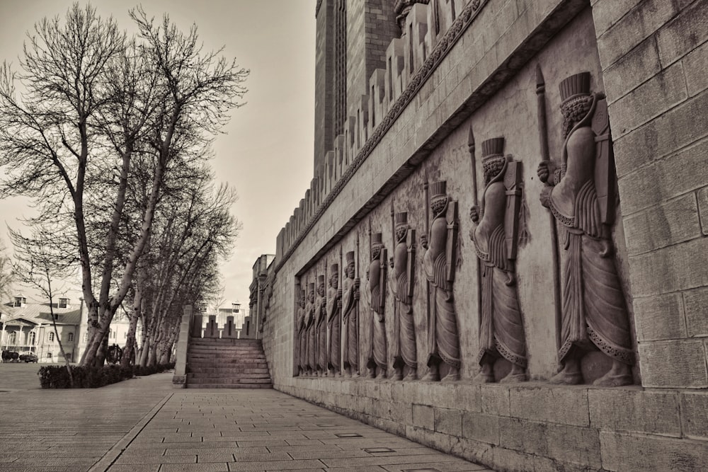 a black and white photo of a wall with statues on it