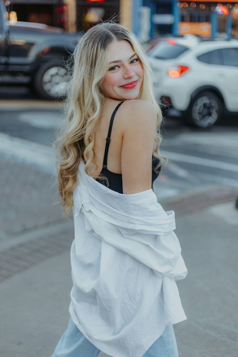 a woman with blonde hair is walking down the street