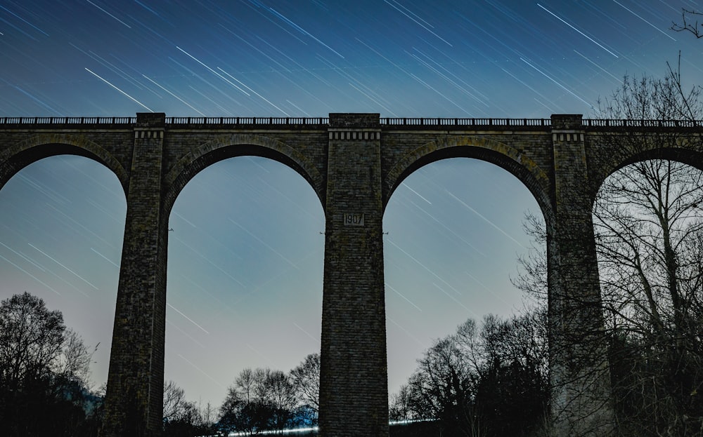 a bridge with arches and stars in the sky