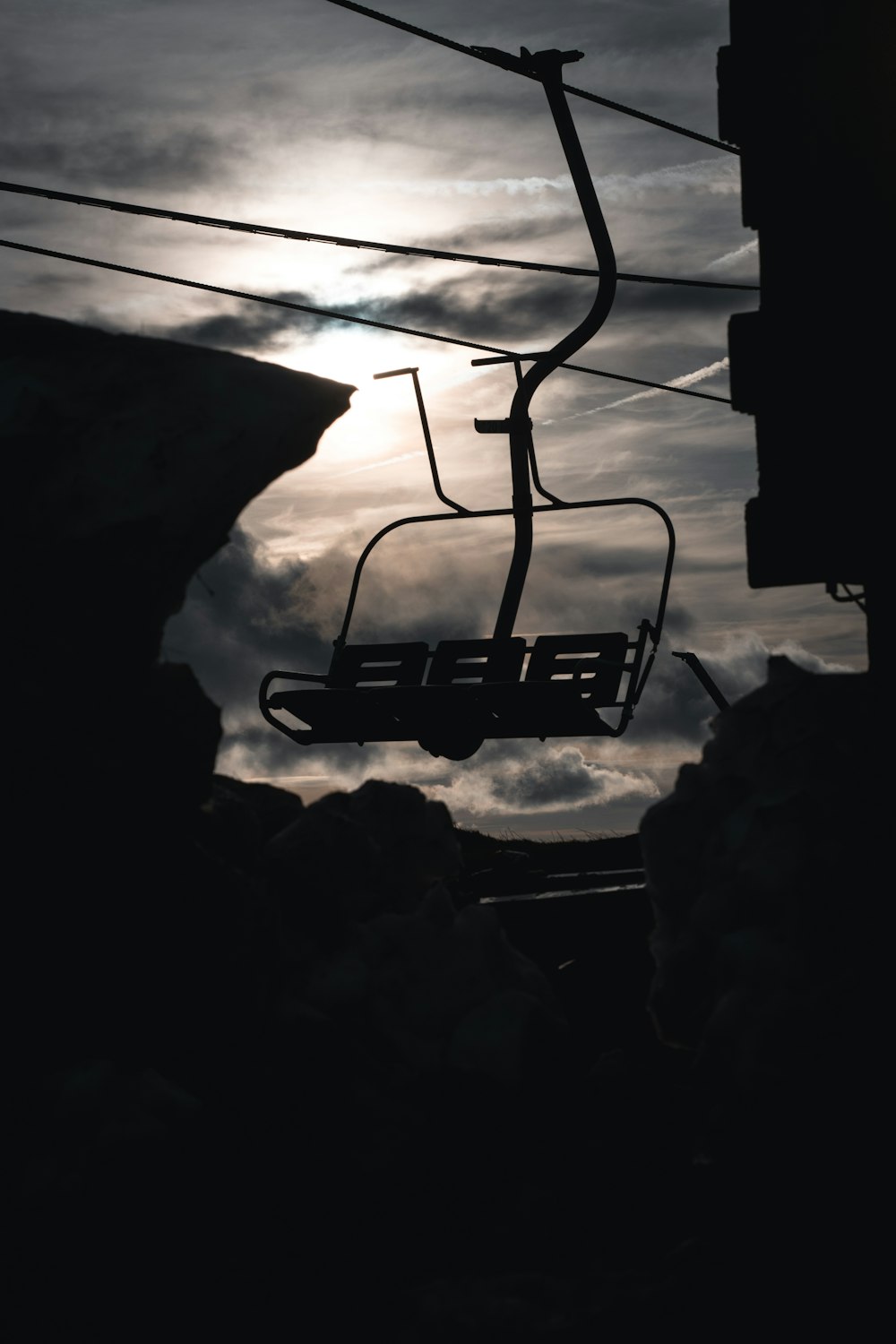 a ski lift with a sky background and clouds