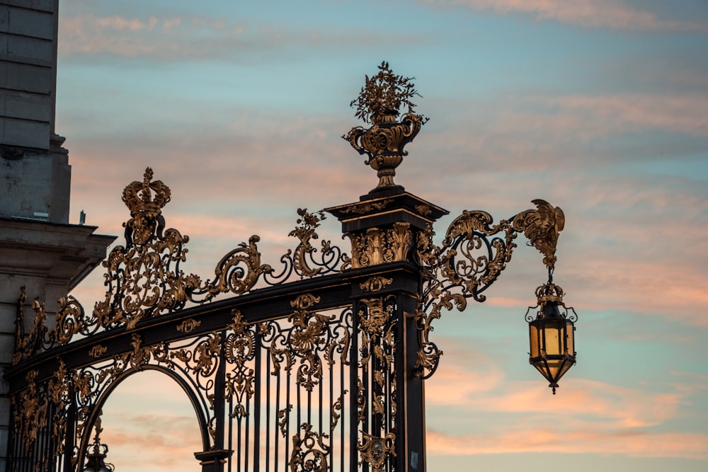 a wrought iron gate with a street light in the background