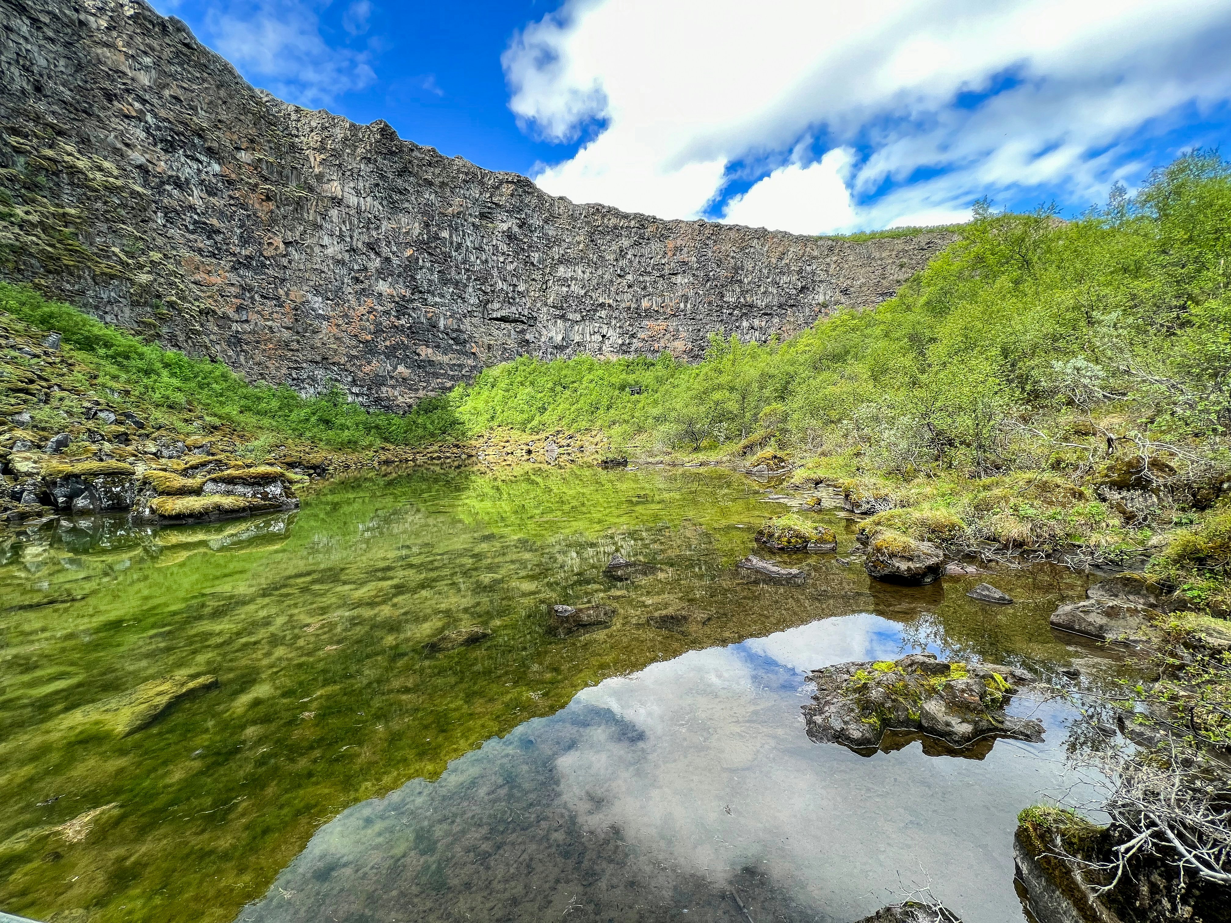 A body of water surrounded by a lush green hillside photo – Free Rock ...