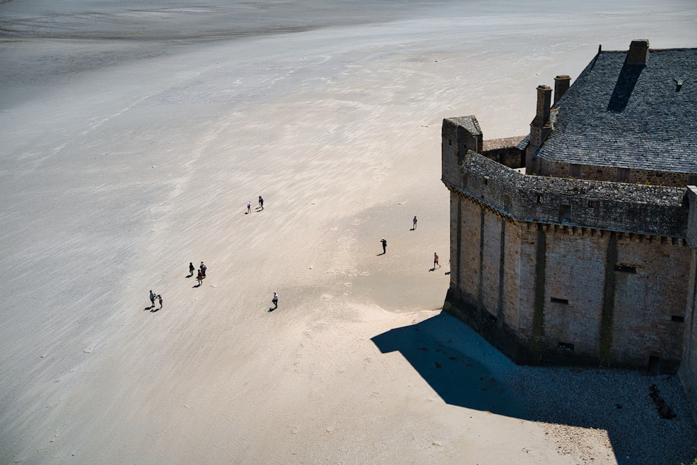 a group of people standing on top of a sandy beach