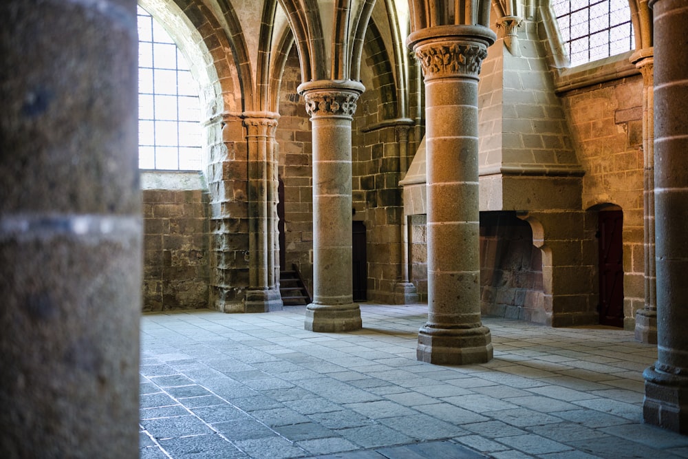 a large room with columns and a fire place