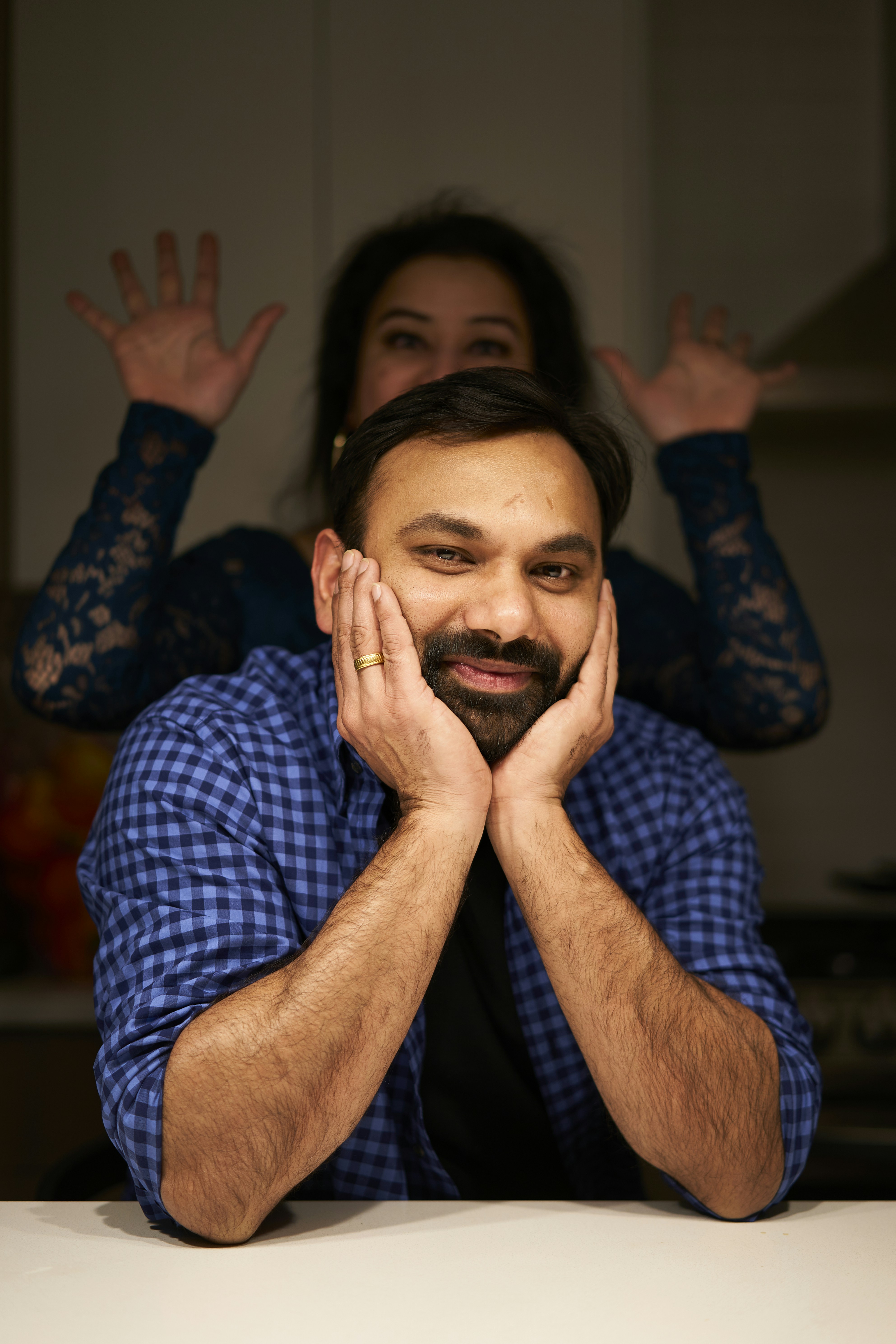a man sitting at a table with his hands on his face