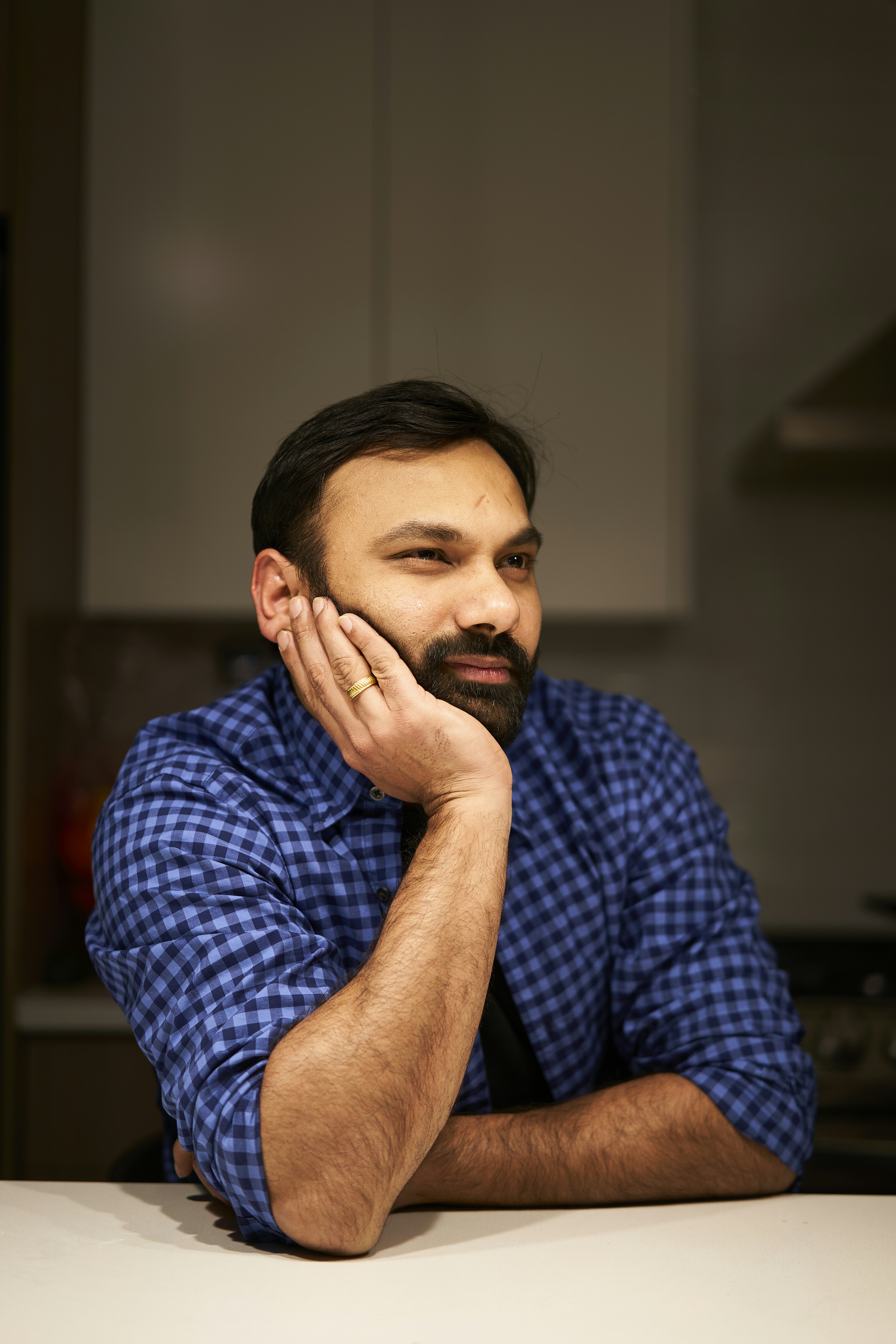 a man sitting at a table with his hand on his face
