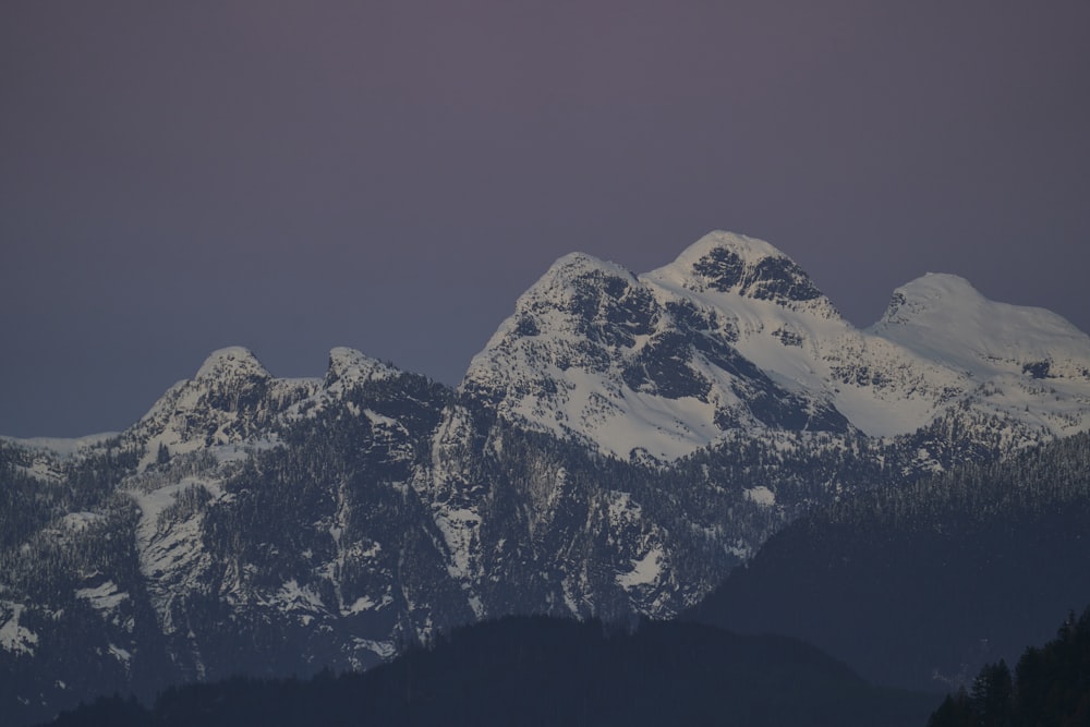 a mountain range with snow covered mountains in the background