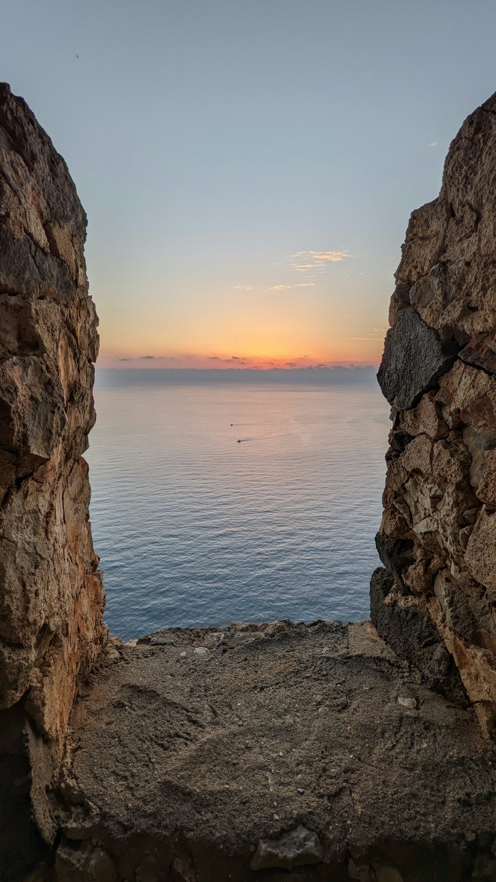 a view of a body of water through two rocks