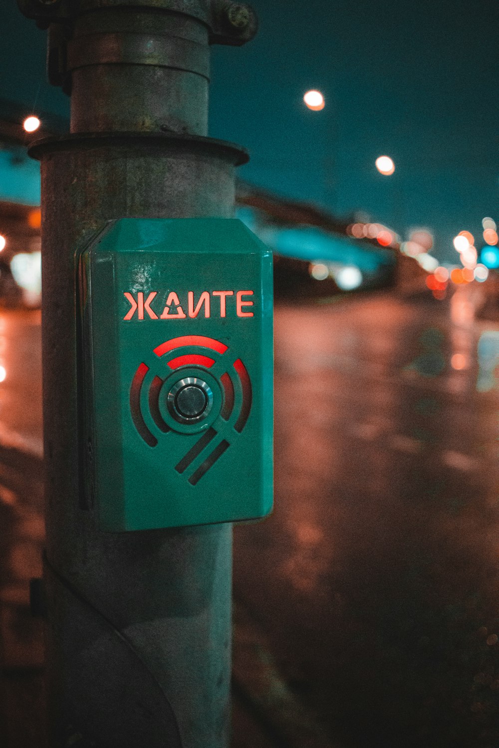 a green sign on a pole on a city street