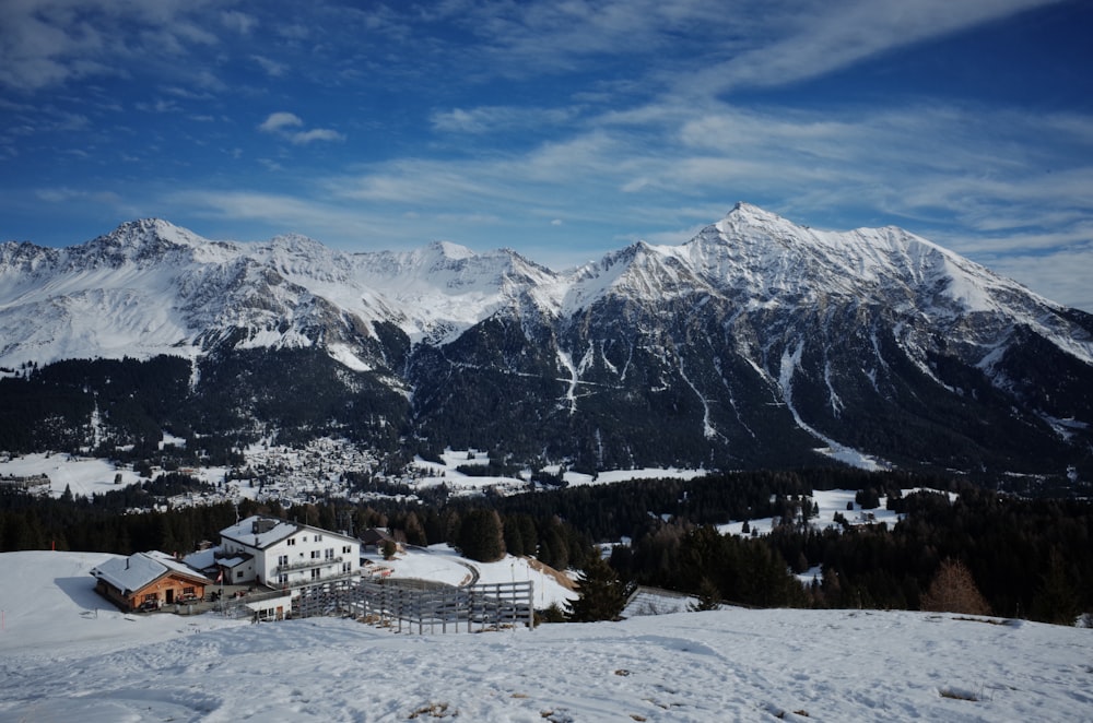 a snow covered mountain with a house in the foreground