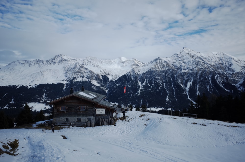 a snow covered mountain with a house in the foreground