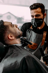 a man getting his hair cut by a barber