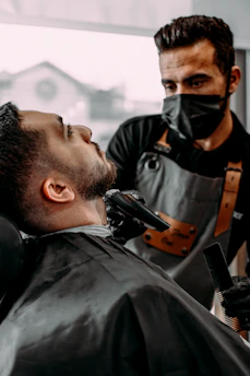a man getting his hair cut by a barber