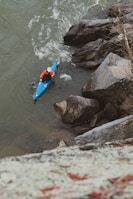 a person in a kayak paddling down a river