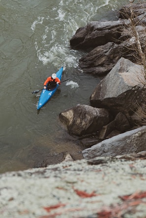 a person in a kayak paddling down a river