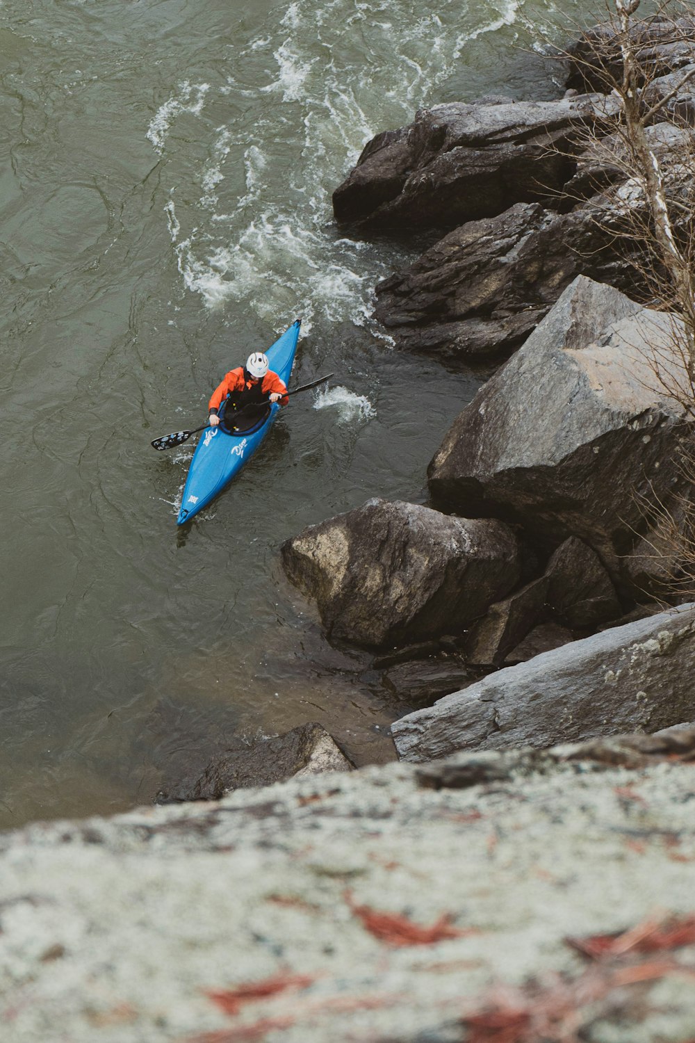 a person in a kayak paddling down a river