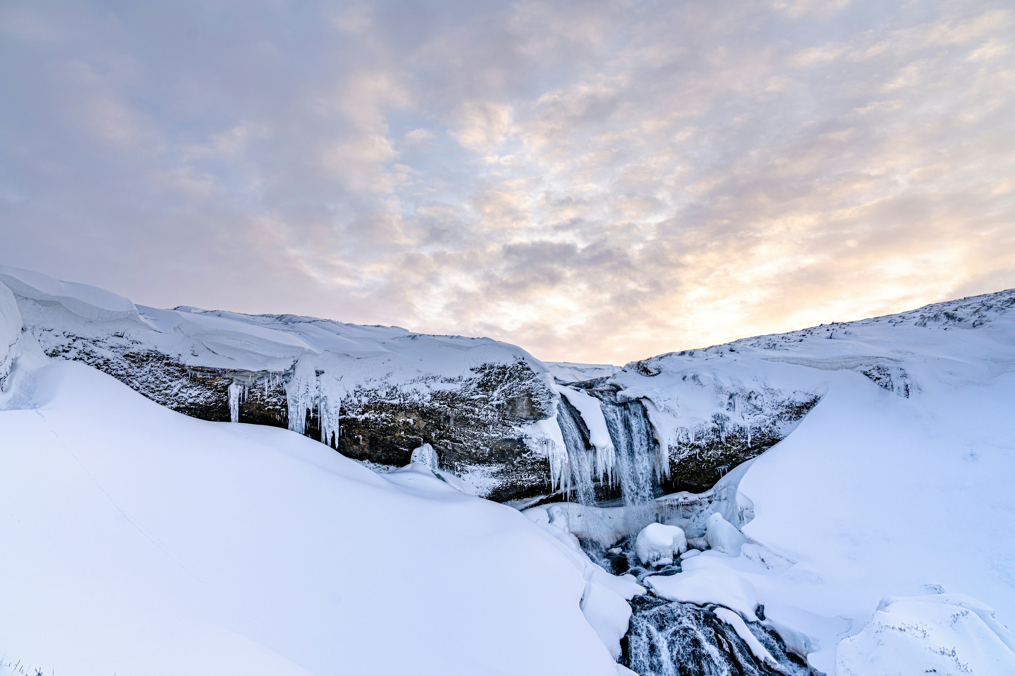Ein schneebedeckter Berg mit einem gefrorenen Wasserfall