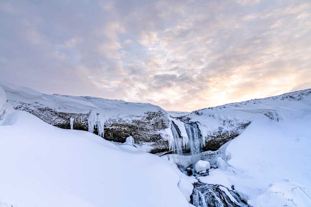 a snow covered mountain with a frozen waterfall