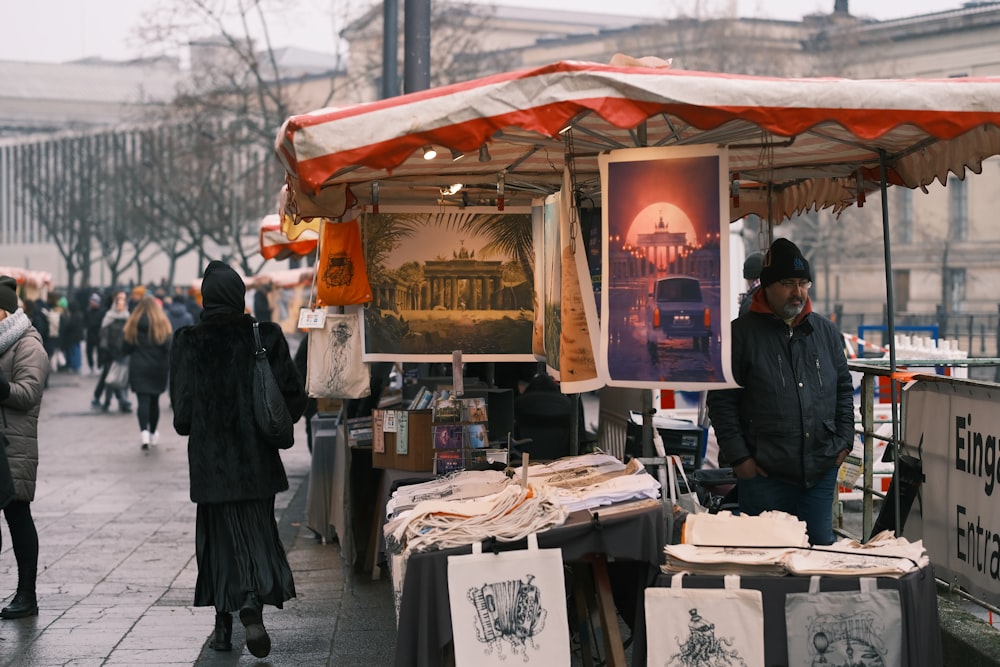 a man standing next to a table with pictures on it