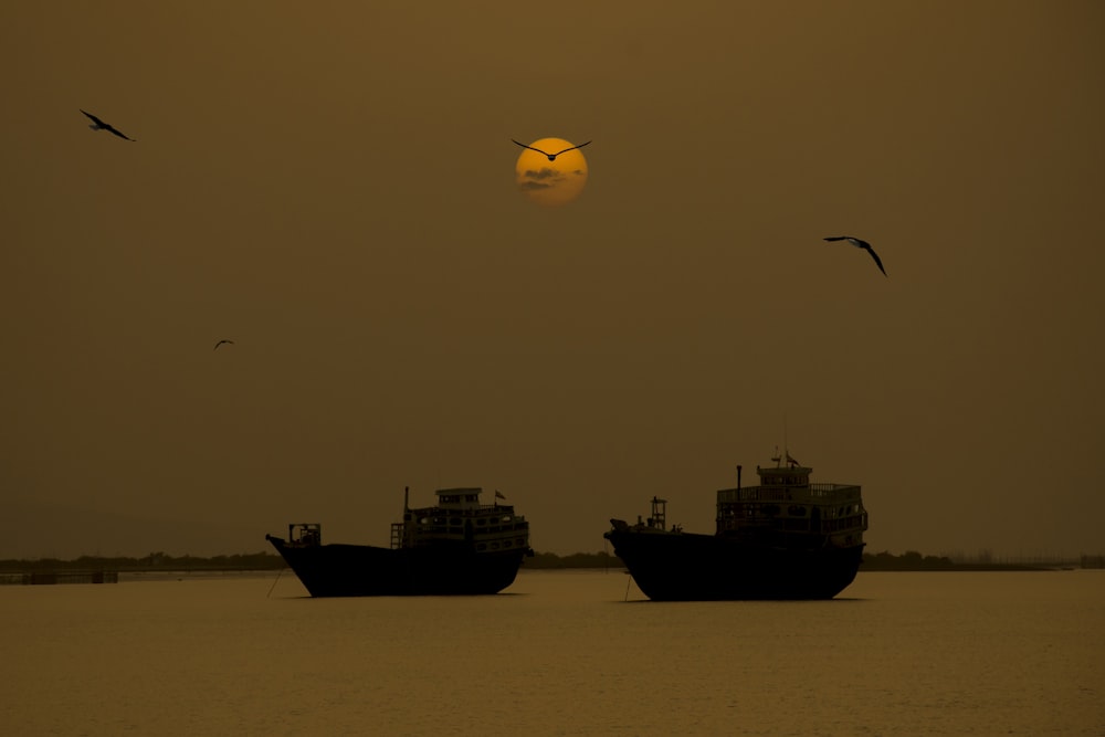 a couple of boats floating on top of a large body of water