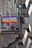 A rainbow-colored flag with the words 'NO WAR' hangs from the railing of a balcony. The building features brick and stone elements, with potted plants visible on the balcony. The atmosphere conveys a message of peace and anti-war sentiment.
