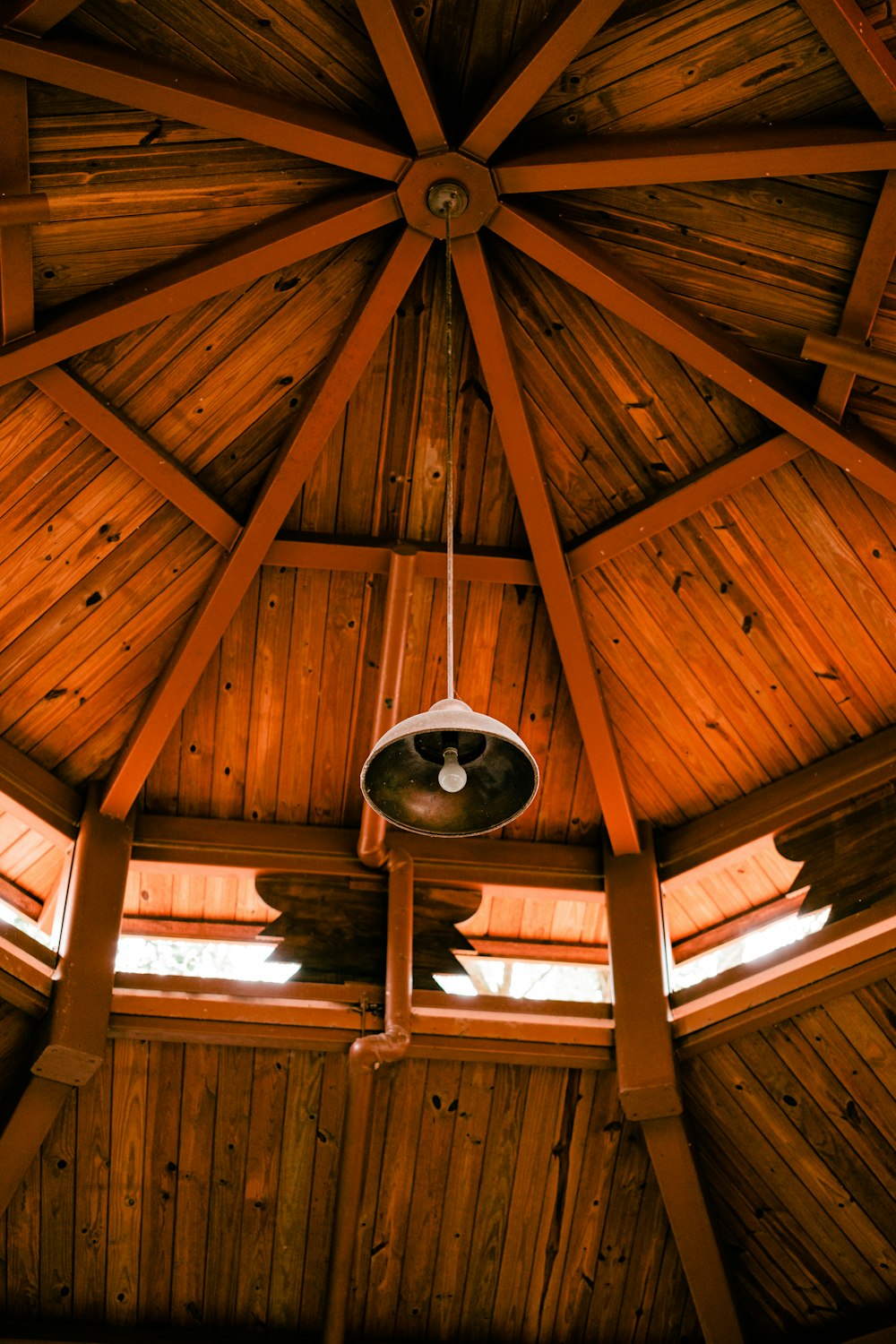 a wooden ceiling with a fan hanging from it's side