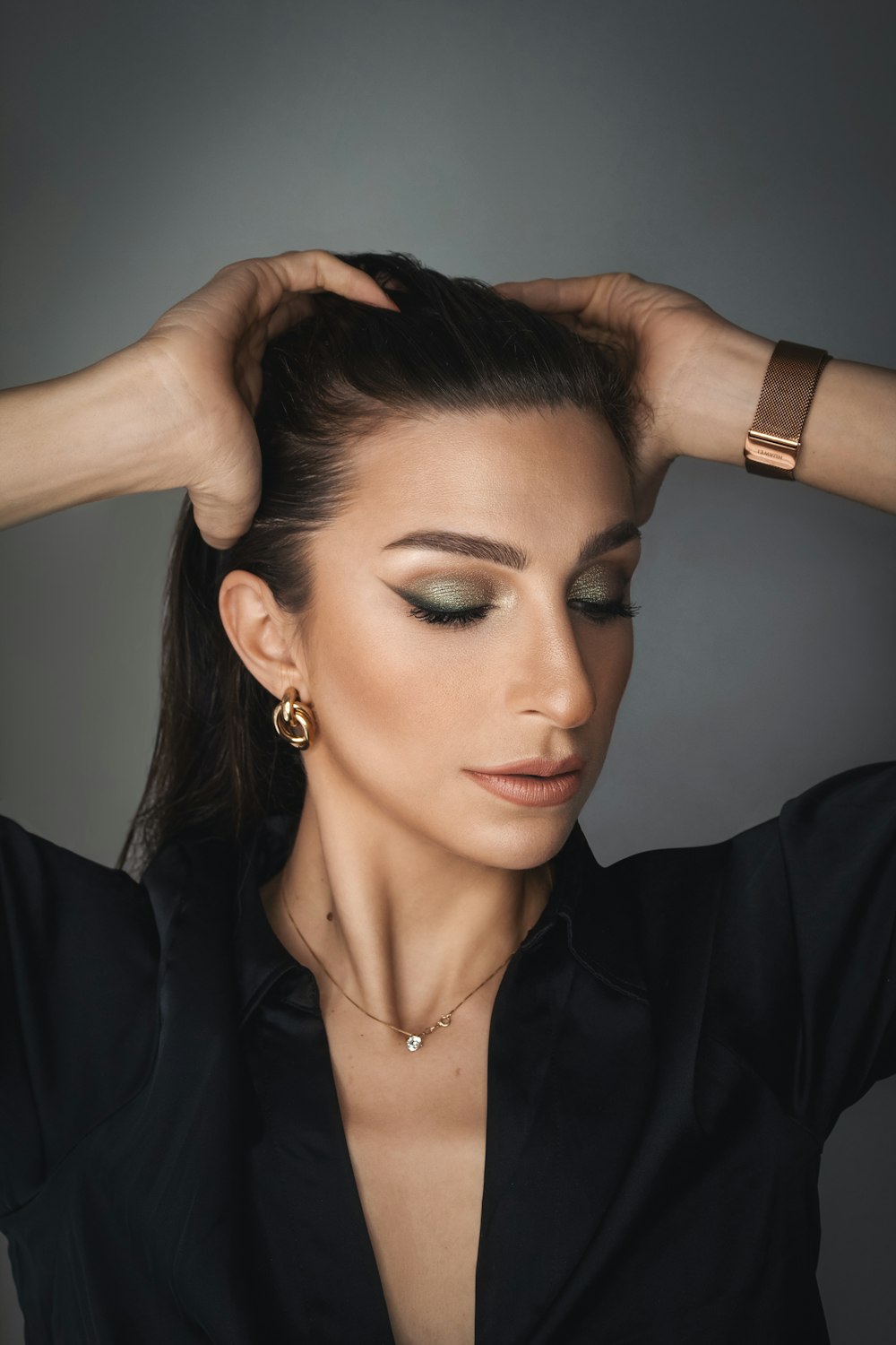 a woman wearing a black shirt and gold earrings