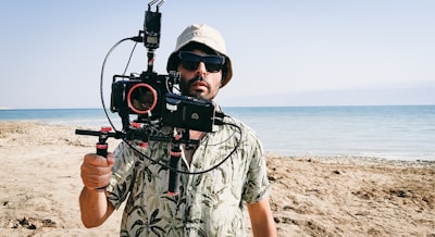 A vibrant photo of a creator filming a travel vlog on a sunny beach.
