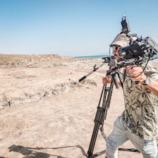 A professional treasure hunter using advanced underground imaging equipment in rugged outdoor landscape.