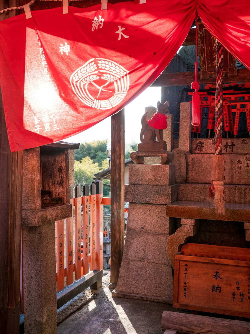 a shrine with a red flag hanging from it's roof