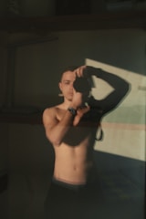 Close-up photo of a man measuring his chest with a soft tape measure in a bright, minimal room.