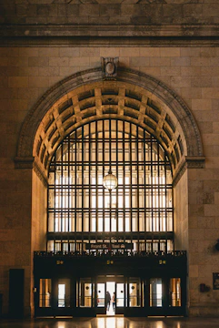 A bright entrance featuring a large glass door framed by elegant metalwork.